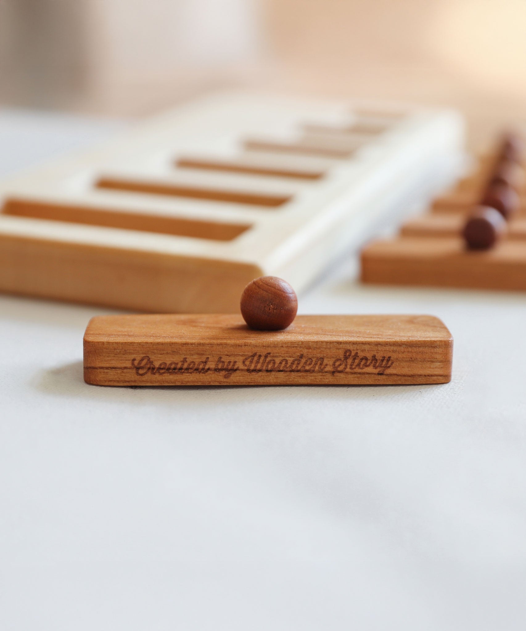 A close up of one of the rectangular shaped pieces that fit in the long short puzzle frame. The words Created by Wooden Story have been etched on the side. 