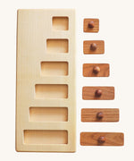 Wooden Story Montessori Long-Short wooden Knob Puzzle Toy. A wooden puzzle including a base frame and 5 rectangular shaped pieces in different lengths with round wooden knobs.  The rectangular pieces are shown out of the frame. 