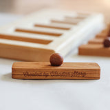 A close up of one of the rectangular shaped pieces that fit in the puzzle frame. The words Created by Wooden Story have been etched on the side. 