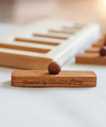 A close up of one of the rectangular shaped pieces that fit in the puzzle frame. The words Created by Wooden Story have been etched on the side. 