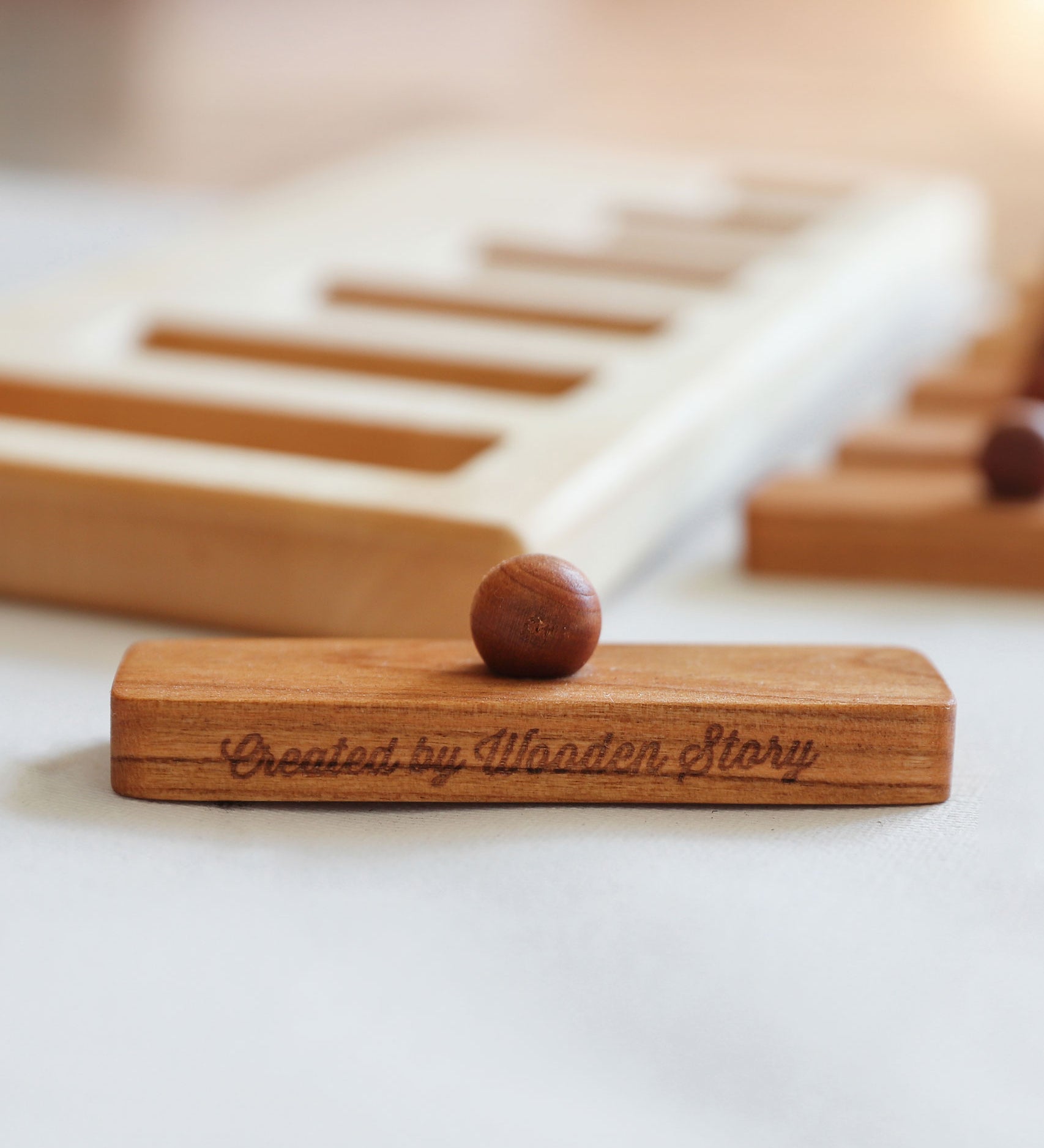 A close up of one of the rectangular shaped pieces that fit in the puzzle frame. The words Created by Wooden Story have been etched on the side. 