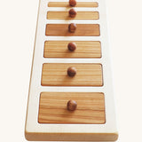 The Wooden Story Montessori Wide-Thin Knob Puzzle. A puzzle with 5 rectangular shaped pieces that fit into a wooden frame.