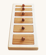 The Wooden Story Montessori Wide-Thin Knob Puzzle. A puzzle with 5 rectangular shaped pieces that fit into a wooden frame.