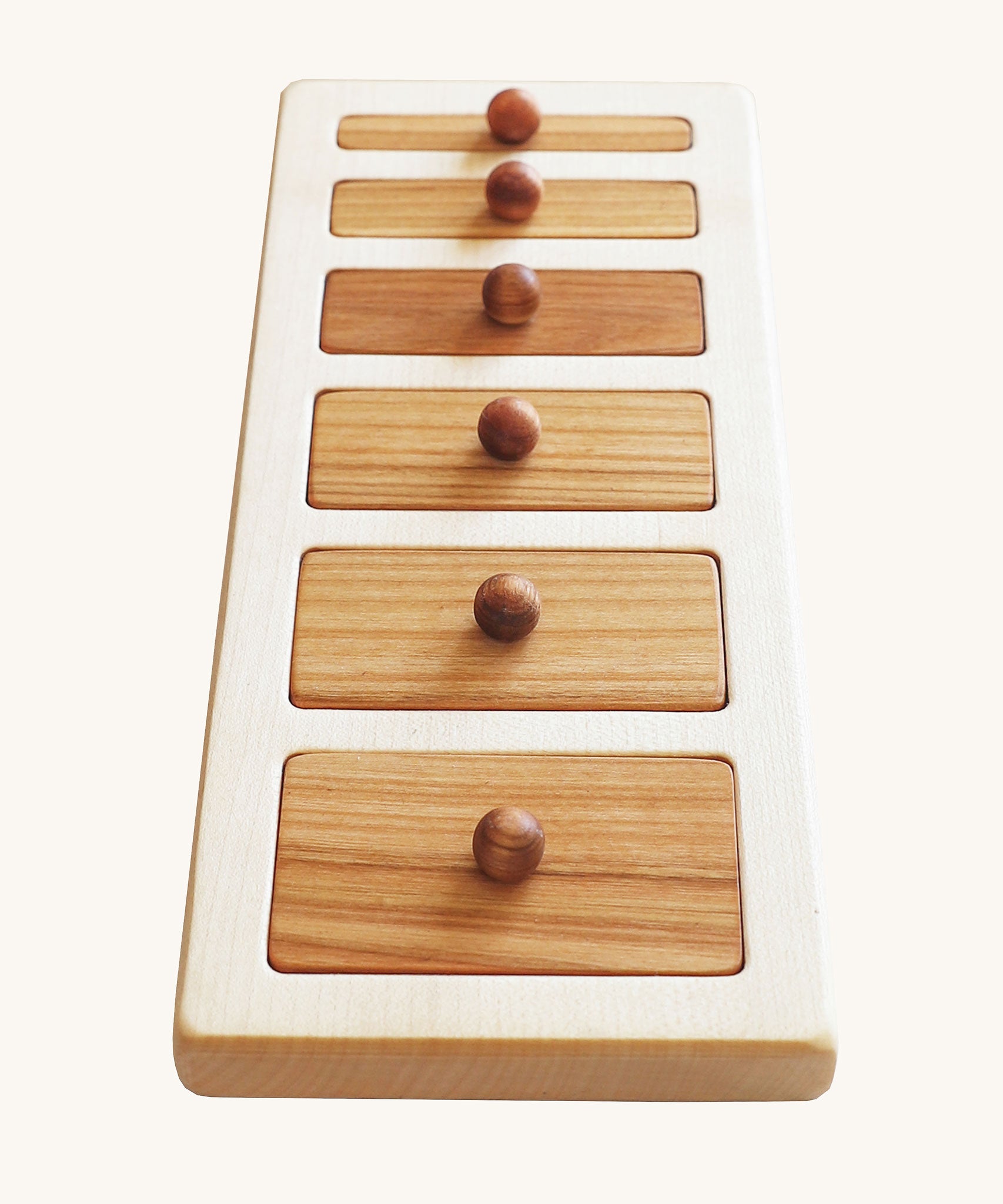 The Wooden Story Montessori Wide-Thin Knob Puzzle. A puzzle with 5 rectangular shaped pieces that fit into a wooden frame.