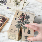 A close up of the blocks from the Wooden Story Melliferous Plants Puzzle Blocks set. A child's c hand can be seen placing the last block down to complete the plant picture.
