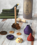 The pieces from the Wooden Story Stacking Toy Stick Purple Number 6 Figure taken off the base pole and paced on a wooden surface. 