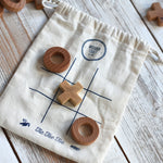 The Wooden Story Tic Tac Toe game shown with the cotton bag base with three pieces on the grid.