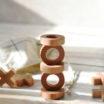 The O pieces from the Wooden Story Tic Tac Toe game stacked on top of each other. 