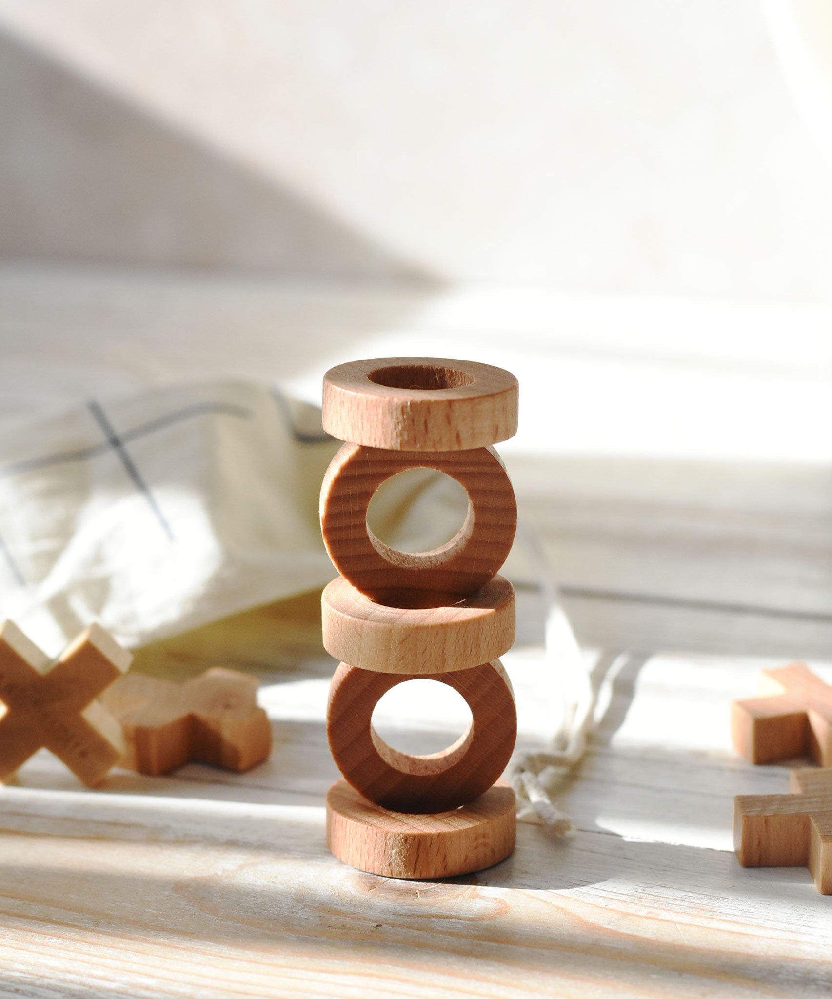 The O pieces from the Wooden Story Tic Tac Toe game stacked on top of each other. 