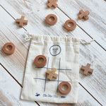 The Wooden Story Tic Tac Toe game. The drawstring storage bag acts as the base for the game as it features a grid.