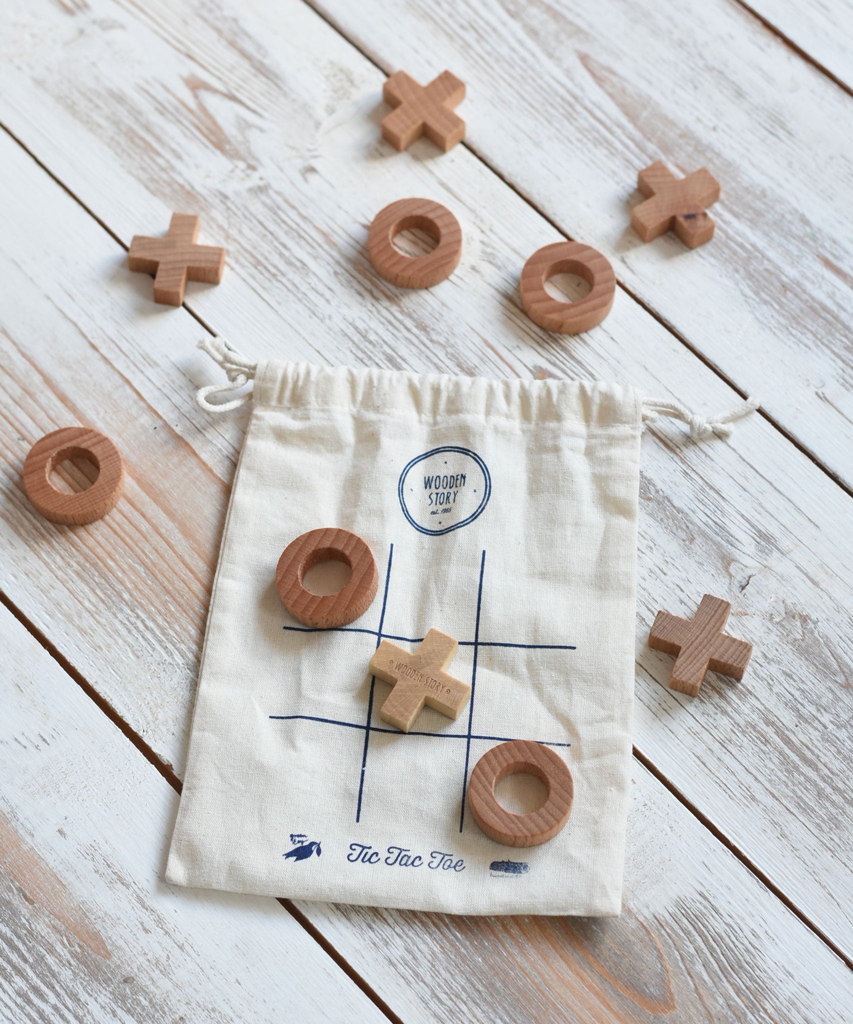 The Wooden Story Tic Tac Toe game. The drawstring storage bag acts as the base for the game as it features a grid.