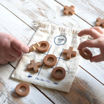 A close up of children playing with the Wooden Story Tic Tac Toe game.