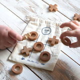 A close up of children playing with the Wooden Story Tic Tac Toe game.