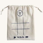 The drawstring bag that comes with the Wooden Story Tic Tac Toe set. A simple 9 space grid has been printed on the front of the bag.
