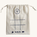 The drawstring bag that comes with the Wooden Story Tic Tac Toe set. A simple 9 space grid has been printed on the front of the bag.