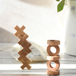 The O and X pieces from the Wooden Story Tic Tac Toe game stacked on top of each other. 