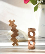 The O and X pieces from the Wooden Story Tic Tac Toe game stacked on top of each other. 