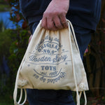 The printed cotton drawstring storage bag being held in an adult's hand. 