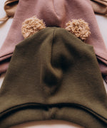 A close up of the Wooly Organic hat with teddy ears in tea leaf / savannah available at Babipur a ribbed style hat showing the cute fluffy teddy bear ears detail 