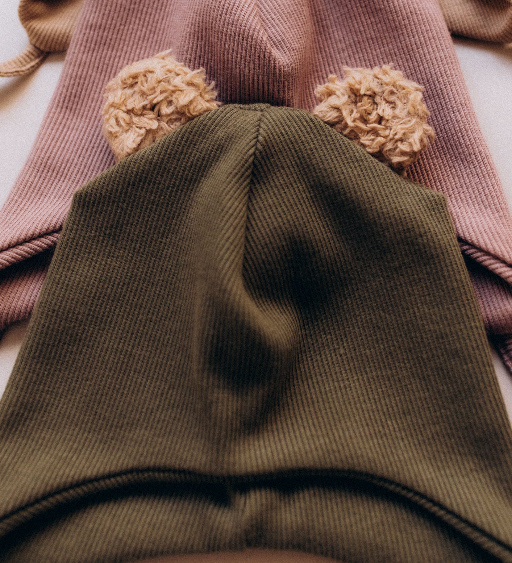 A close up of the Wooly Organic hat with teddy ears in tea leaf / savannah available at Babipur a ribbed style hat showing the cute fluffy teddy bear ears detail 