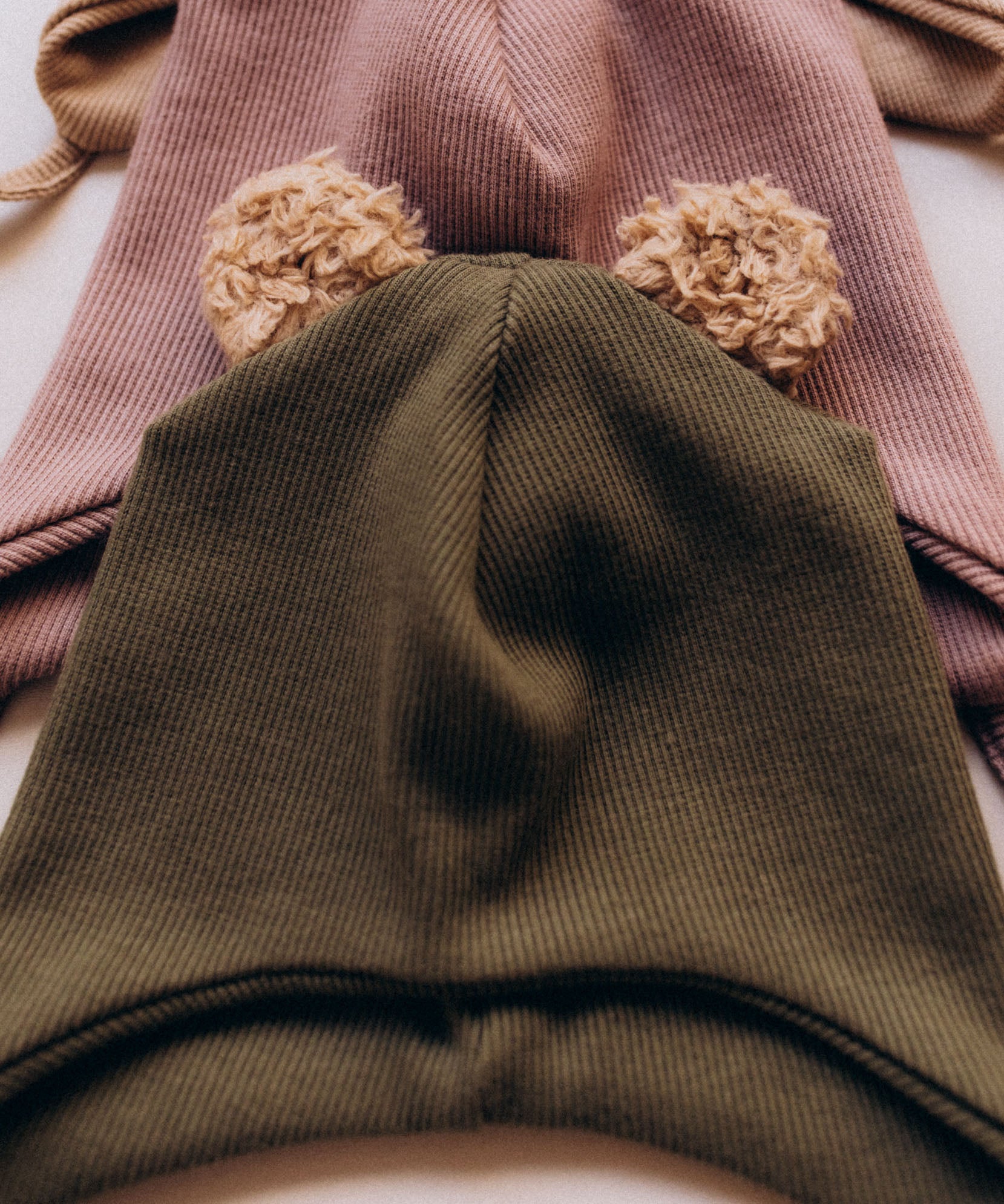 A close up of the Wooly Organic hat with teddy ears in tea leaf / savannah available at Babipur a ribbed style hat showing the cute fluffy teddy bear ears detail 