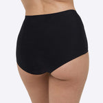 A person wearing the WUKA Stretch Boxer Shorts Heavy Flow - Black