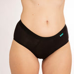Close up of woman wearing the WUKA eco-friendly midi brief everyday pants on a white background