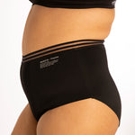 Close up of woman stood sideways on a white background wearing the WUKA re-purpose high waisted heavy flow period pants