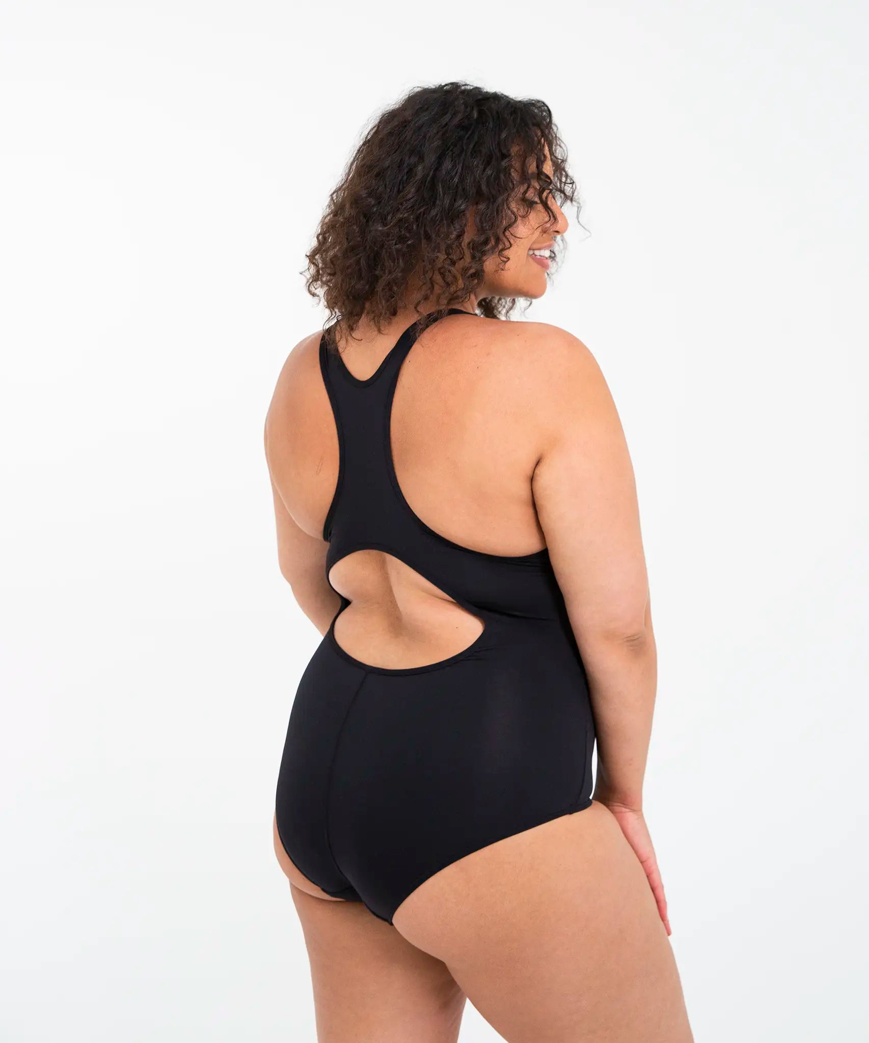 Side of woman wearing the Wuka perform period light/medium flow swimsuit in black
