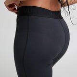 Back of woman wearing the Wuka performance leggings in black showing the elasticated waist band and side pocket