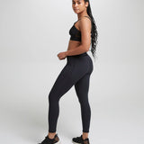 Side of woman wearing the Wuka performance leggings in black 