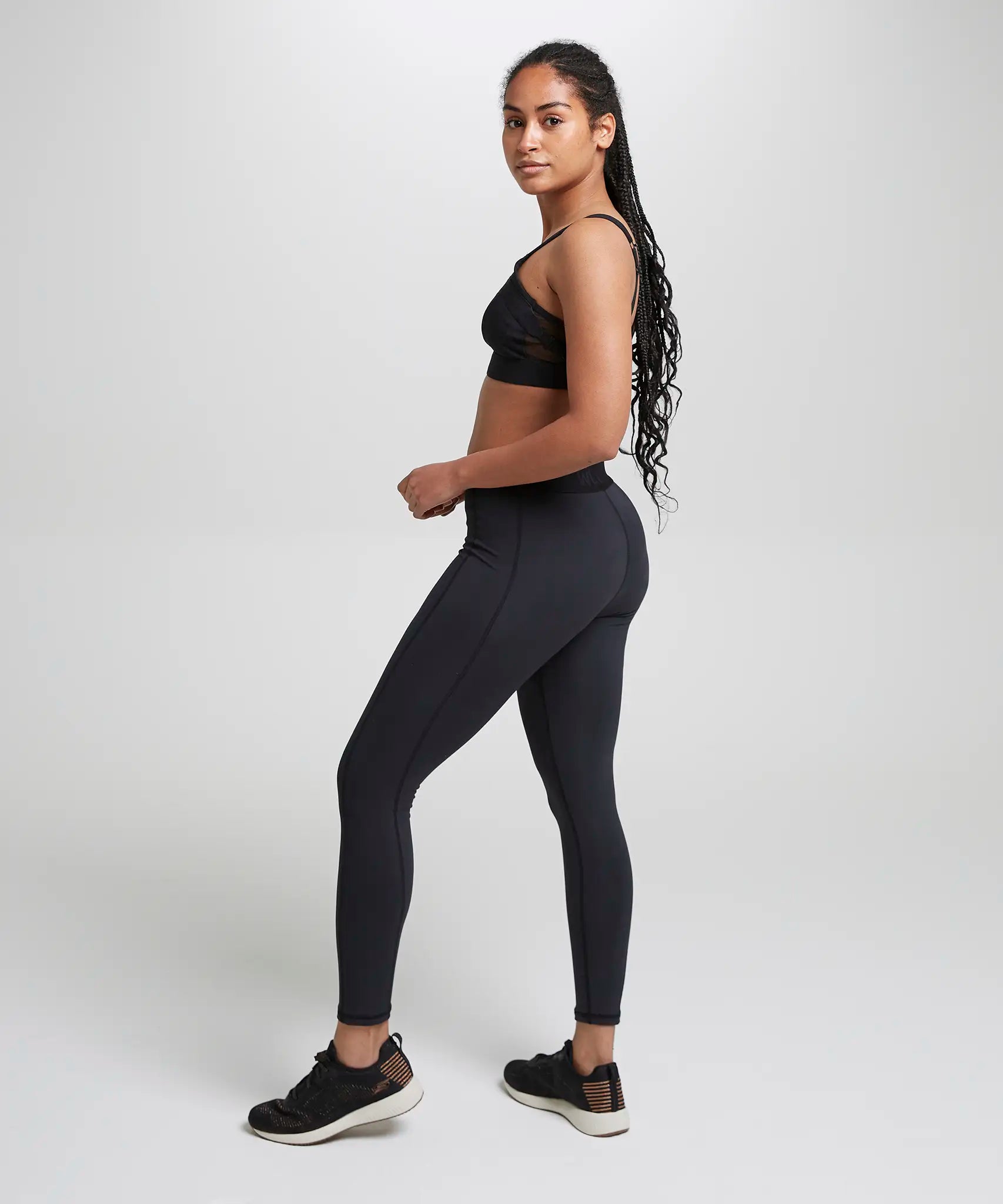 Side of woman wearing the Wuka performance leggings in black 