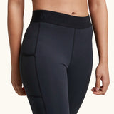 Front of woman wearing the Wuka performance leggings in black showing the elasticated waist band and side pocket