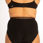 Close up of woman stood backwards on a white background wearing the WUKA re-purpose high waisted heavy flow period pants
