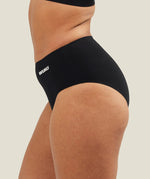 Side view of a model wearing WUKA Seamless Midi Brief period underwear, showing the stretch fit across the hips and the smooth, body-contouring shape.