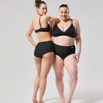 Two people wearing the WUKA Stretch Boxer Shorts Heavy Flow - Black