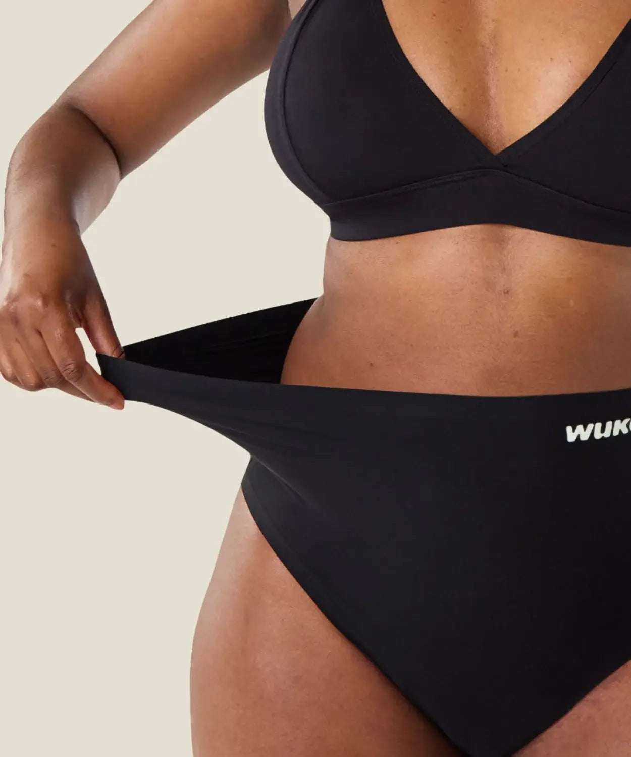 Woman stretching the waist on the Wuka seamless stretch high waisted period pants
