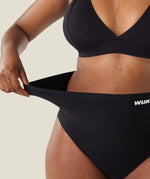 Woman stretching the waist on the Wuka seamless stretch high waisted period pants