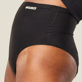 Side of woman wearing the Wuka stretch high waisted period pants showing seamless detail