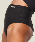Side of woman wearing the Wuka stretch high waisted period pants showing seamless detail