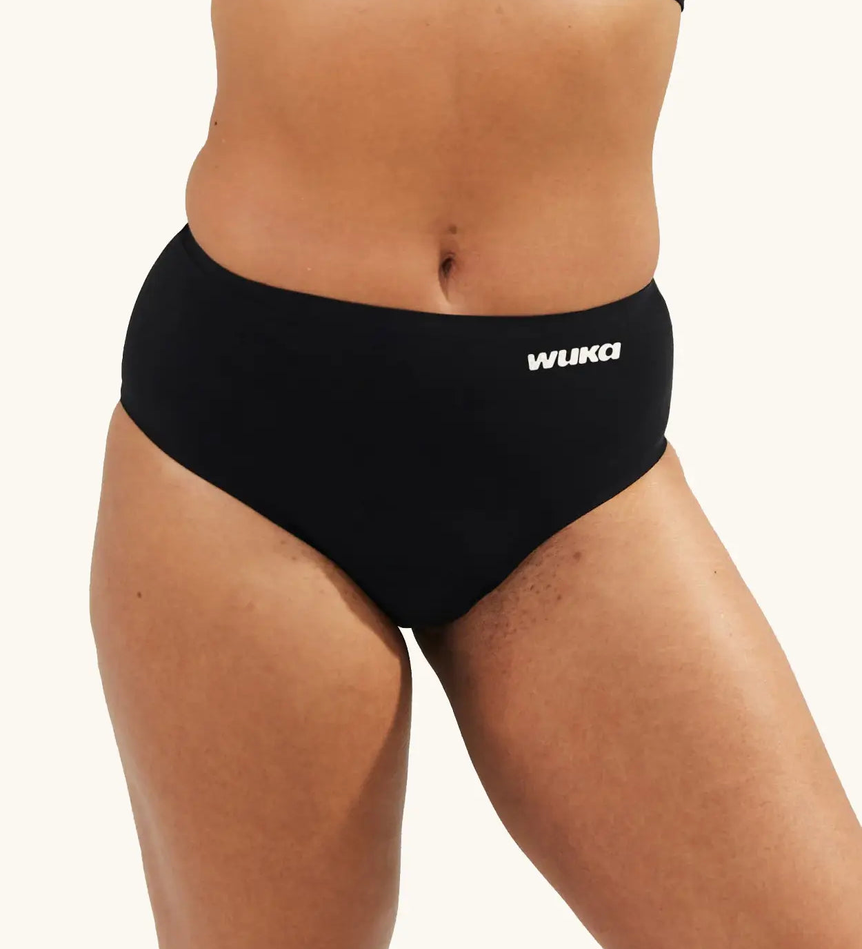 Front of woman wearing the Wuka stretch seamless midi heavy flow period brief in black