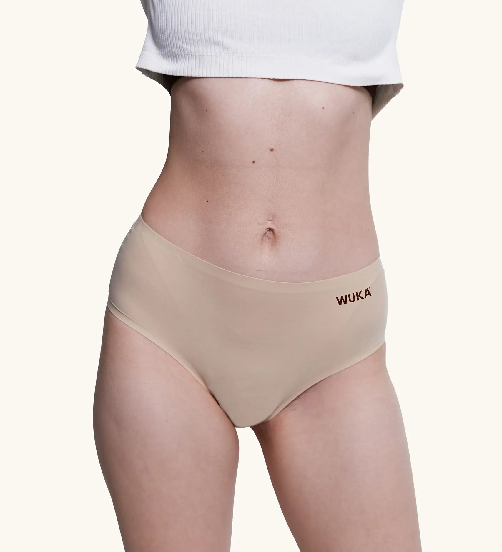Front of model wearing the Wuka stretch midi brief seamless period pants in neutral