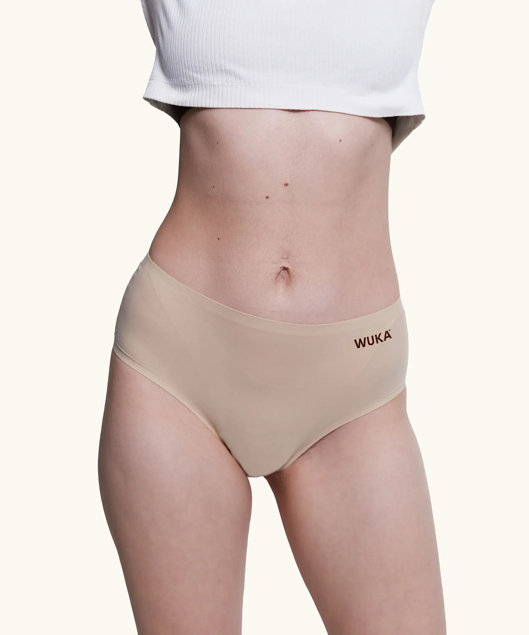 Front of model wearing the Wuka stretch midi brief seamless period pants in neutral