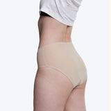 Side of model wearing the Wuka stretch seamless midi brief period pants in neutral