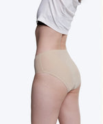 Side of model wearing the Wuka stretch seamless midi brief period pants in neutral