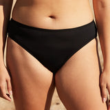 Front of woman wearing the WUKA swim bikini light flow period pants in black