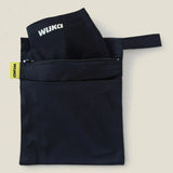 An open Wuka changing bag in black with a period pants in one compartment