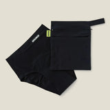 Wuka two pocket changing bag in black laid flat next to a pair of period pants