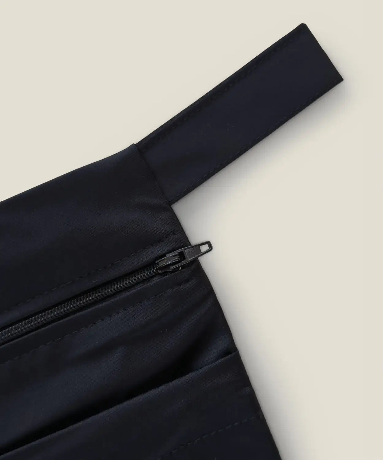 Wuka two pocket changing bag in black showing close up of zipper and carry loop detail