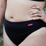 Woman earing the Wuka ultimate bikini style medium flow period brief showing elasticated waistband detail 
